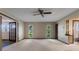 A large bedroom contains light carpeting, a fan, and two windows at 9601 Ambleside Dr, Windermere, FL 34786