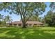 Well-manicured lawn and mature trees enhance this home's curb appeal, perfect for enjoying outdoor living at 9601 Ambleside Dr, Windermere, FL 34786