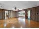 Spacious living room features hardwood floors, wood paneling, ceiling fan, and lots of natural light at 9601 Ambleside Dr, Windermere, FL 34786