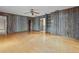 Wide living room features hardwood floors, wood paneling, ceiling fan, and lots of natural light at 9601 Ambleside Dr, Windermere, FL 34786