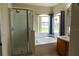 Bathroom featuring a glass shower, soaking tub, and window with natural light at 1001 Dampierre Ct, Kissimmee, FL 34759