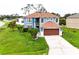 Two-story home featuring a lawn with palm trees, and a large garage at 1001 Dampierre Ct, Kissimmee, FL 34759