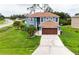 Aerial view of a blue, two-story home with a well-manicured lawn and mature palm trees at 1001 Dampierre Ct, Kissimmee, FL 34759