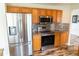 Kitchen featuring stainless steel appliances, tiled backsplash, and wood cabinetry at 1001 Dampierre Ct, Kissimmee, FL 34759