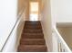 Carpeted staircase with white railings, providing access to upper floors of the house at 1001 Dampierre Ct, Kissimmee, FL 34759