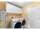 Laundry room with washer, dryer, and overhead storage cabinets at 1003 Jackson Creek Ct, Oviedo, FL 32765