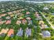 An aerial view shows homes in a well-established neighborhood surrounded by mature trees and ponds at 11015 Hawkshead Ct, Windermere, FL 34786