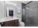 This bathroom features tile floors, dark wood cabinets, a mirror, a shower and a window at 11015 Hawkshead Ct, Windermere, FL 34786