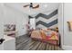 Cozy bedroom with wood-look floors, a chevron accent wall, and charming decor at 11015 Hawkshead Ct, Windermere, FL 34786