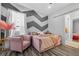 Stylish bedroom with wood-look floors, a chevron accent wall, and comfortable seating at 11015 Hawkshead Ct, Windermere, FL 34786
