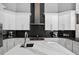 Contemporary kitchen showcasing white cabinetry, black backsplash and stainless steel range at 11015 Hawkshead Ct, Windermere, FL 34786