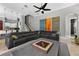 Inviting living room featuring a large black leather sectional sofa and view to the kitchen and stairs at 11015 Hawkshead Ct, Windermere, FL 34786