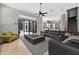 Spacious living room features a sleek black leather couch and seamless flow to the kitchen at 11015 Hawkshead Ct, Windermere, FL 34786
