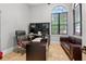 Bright office space with a large window, dark desk, and comfortable leather seating at 11015 Hawkshead Ct, Windermere, FL 34786