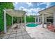 Lush backyard pool and spa area features a travertine deck, covered lanai, pergola, and privacy landscaping at 11015 Hawkshead Ct, Windermere, FL 34786