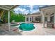 Gorgeous backyard pool and spa with travertine deck, outdoor lounge area, and privacy landscaping at 11015 Hawkshead Ct, Windermere, FL 34786