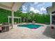 Backyard pool with travertine deck, grill, pergola, privacy landscaping, and room to relax and enjoy the outdoors at 11015 Hawkshead Ct, Windermere, FL 34786