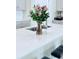 Bright kitchen island featuring white countertops, a stainless steel sink, and a lovely floral centerpiece at 11408 Satire St, Orlando, FL 32832