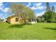 Spacious backyard featuring lush green lawn, mature tree and storage shed at 1406 Sean Ct, St Cloud, FL 34772