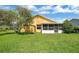 View of the home's backyard showcasing ample green space and a storage shed at 1406 Sean Ct, St Cloud, FL 34772