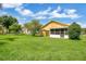 Backyard view showing spacious green area, a shed, and screened patio at 1406 Sean Ct, St Cloud, FL 34772