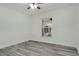 This bedroom features bright natural light, a ceiling fan, and sleek, modern gray wood flooring at 1406 Sean Ct, St Cloud, FL 34772