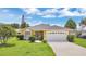 Charming yellow single-story home featuring a well-maintained lawn and a two-car garage at 1406 Sean Ct, St Cloud, FL 34772