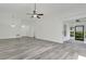Bright living room featuring new flooring, a ceiling fan, and sliding door access at 1406 Sean Ct, St Cloud, FL 34772