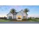 Stunning exterior view of the community clubhouse with a white facade, black windows, and mature palm trees at 1515 Stonecliff Dr, Apopka, FL 32703