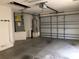 A clean and spacious garage with a water heater, HVAC system, and an automatic overhead door at 1524 Conway Ct, The Villages, FL 32162