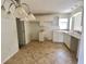 Traditional-style kitchen featuring tile flooring and white cabinetry, awaiting your personal touch at 1524 Conway Ct, The Villages, FL 32162