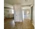 View from kitchen showing tile flooring, white cabinets and views to the living area beyond at 1524 Conway Ct, The Villages, FL 32162