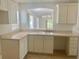 Bright kitchen with white cabinetry, a window over the sink, and tile flooring at 1524 Conway Ct, The Villages, FL 32162