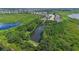 An aerial view of a neighborhood showcases homes nestled amidst lush greenery and scenic ponds in a tranquil setting at 15344 Johns Lake Pointe Blvd, Winter Garden, FL 34787