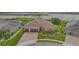 Aerial view showcases this residence featuring a three-car garage, manicured lawn, and paver driveway at 15344 Johns Lake Pointe Blvd, Winter Garden, FL 34787