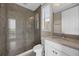 Bathroom features a glass shower, large window, and vanity with sink at 15344 Johns Lake Pointe Blvd, Winter Garden, FL 34787