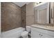A well-lit bathroom featuring tiled walls, a shower-tub combo, a toilet, and a vanity sink with white cabinetry at 15344 Johns Lake Pointe Blvd, Winter Garden, FL 34787