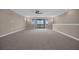 Large upstairs bonus room with neutral carpet, recessed lighting, and a sliding glass door to the balcony at 15344 Johns Lake Pointe Blvd, Winter Garden, FL 34787
