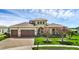 A beautifully landscaped house with a three-car garage and well-manicured lawn at 15344 Johns Lake Pointe Blvd, Winter Garden, FL 34787