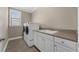 Well-lit laundry room with white washer and dryer, a sink and cabinets, and a large window for natural light at 15344 Johns Lake Pointe Blvd, Winter Garden, FL 34787