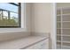 Bright laundry room with a large window, ample counter space, and adjacent white shelving at 15344 Johns Lake Pointe Blvd, Winter Garden, FL 34787