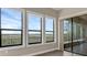 Bright sun room with scenic views from large windows and access to an outdoor patio at 15344 Johns Lake Pointe Blvd, Winter Garden, FL 34787