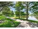 Picturesque walking path next to a serene pond, shaded by trees, offers a peaceful retreat for nature lovers at 15344 Johns Lake Pointe Blvd, Winter Garden, FL 34787