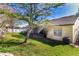 A large grassy yard features mature trees and partial views of the screened in patio and the side of the house at 1662 Canoe Creek Rd, Oviedo, FL 32766