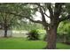 Picturesque backyard featuring a mature tree, green lawn, and classic white picket fence at 1868 Hammock Moss Dr, Orlando, FL 32820