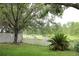 Serene backyard view with lush greenery, mature trees, and a picturesque fence lining the waterfront at 1868 Hammock Moss Dr, Orlando, FL 32820