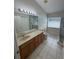 Bathroom with tile floors, glass enclosed shower, large vanity, and window at 1868 Hammock Moss Dr, Orlando, FL 32820