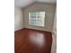 Cozy bedroom featuring laminated wood floors, a large window with natural light, and neutral walls at 1868 Hammock Moss Dr, Orlando, FL 32820