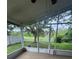 Screened-in patio with tile floors and view to wooded backyard with white picket fence at 1868 Hammock Moss Dr, Orlando, FL 32820
