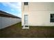 Rear exterior view showing the back door, privacy fence, and some grass at 208 Oleander St, Winter Haven, FL 33881